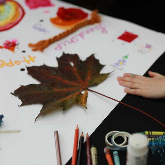 A large autumn leaf and painted rainbow on the collage